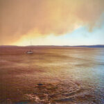 The smoke cloud continues to grow above the beach as it rolls out to Jervis Bay