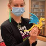 Librarian, biologist and tech educator Amy Maggi holds a dragon made with the 3-D printer in the Boundary County Library's Fab Lab