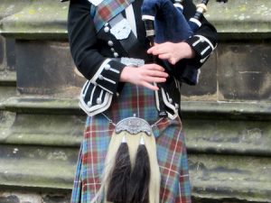 A Scottish piper plays bagpipe on the Royal Mile in Edinburgh